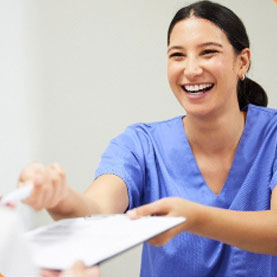 White Oak Dental
happy dental assistant handing a form to a patient